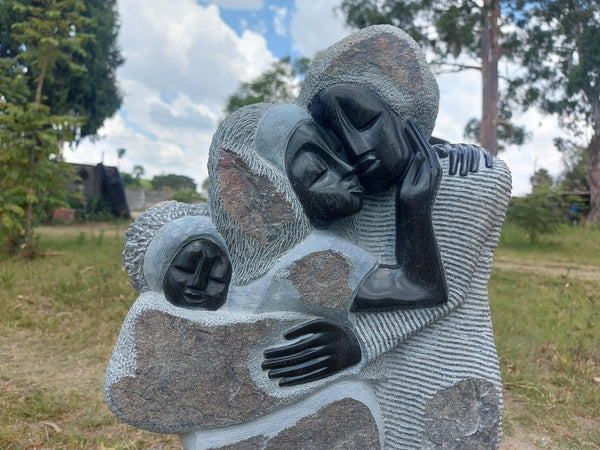 stenen beeld van een familie met baby op de rug