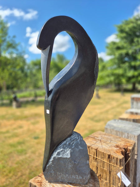 gestileerde vogel in steen, beeldhouwwerk voor buiten, gemaakt door Julius Murenza, wereldbeeld Hamme beeldentuin
