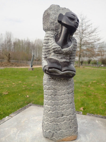 vrouw met boek beeld in steen