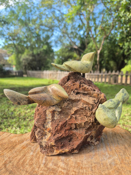 beeld vogeltjes in steen op een rots