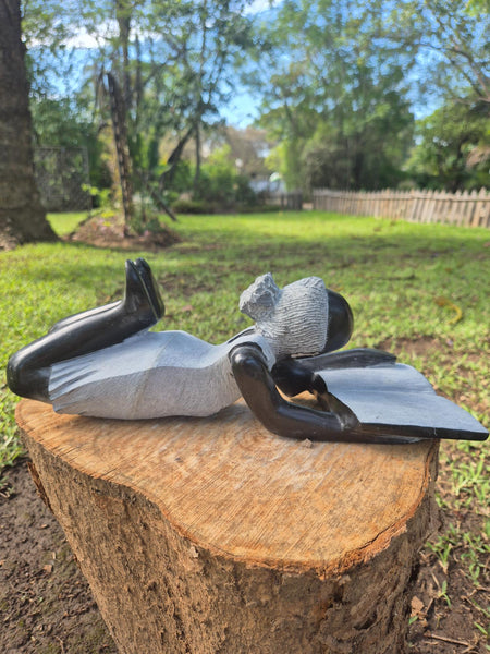 beeld van een meisje dat een boek leest, shona kunst, zimbabwe