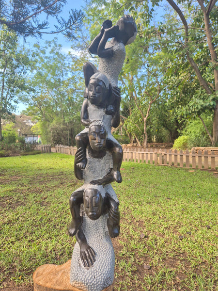 stone statue, 4 girls sitting in each others shoulders
