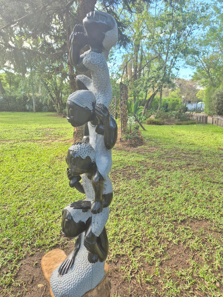 stenen tuinbeeld, 4 meisjes die in elkaars schouders zitten