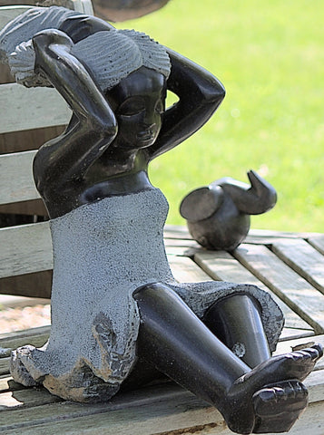 tuinbeeld zittend meisje op bank