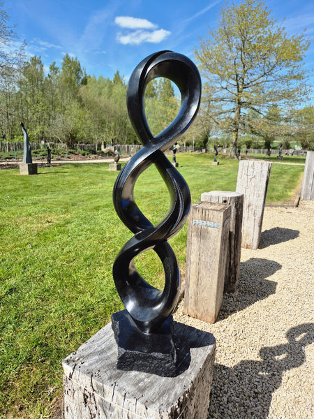 beeld in steen, oneindigheid, mooie vorm, 3 rondingen boven elkaar, gemaakt door Julius Murenza