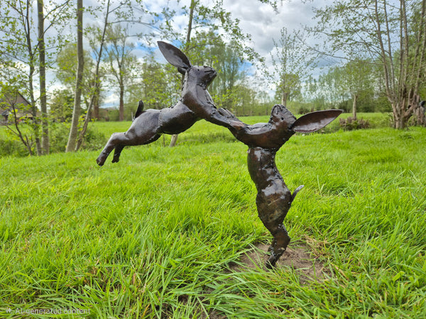 metalen beeld springende konijnen, wereldbeeld driegoten hamme